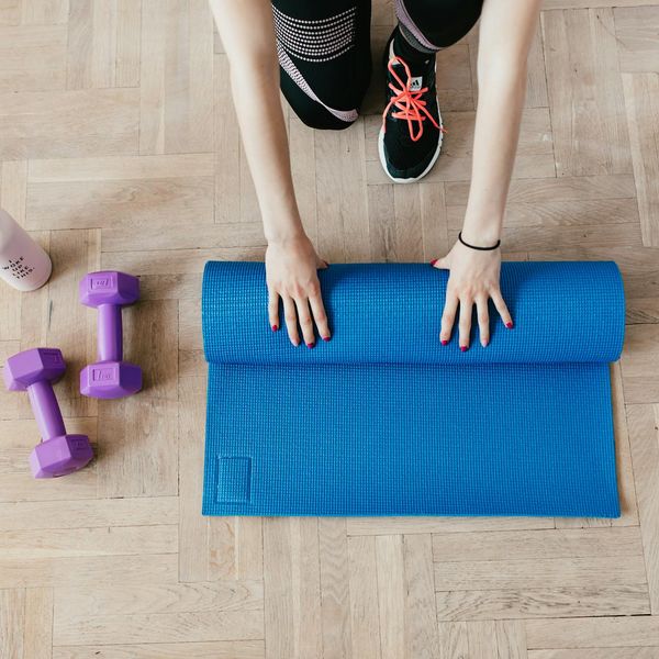 Yoga mat and water bottle on a dark floor